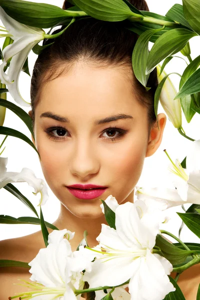 Schoonheid gezicht van een vrouw met bloemen. — Stockfoto