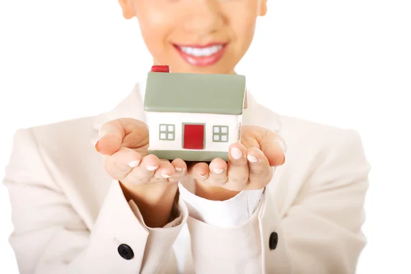 Podnikatelka drží malý domek na dlani. — Stock fotografie