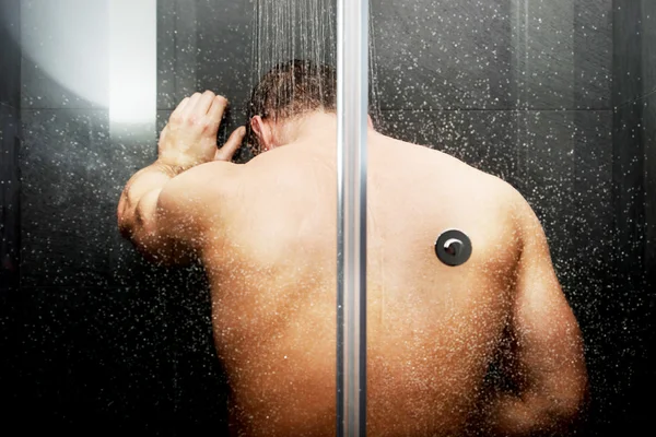 Pohledný muž ve sprše. — Stock fotografie