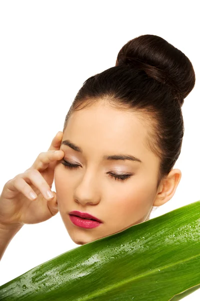 Mooie vrouw met groen blad. — Stockfoto