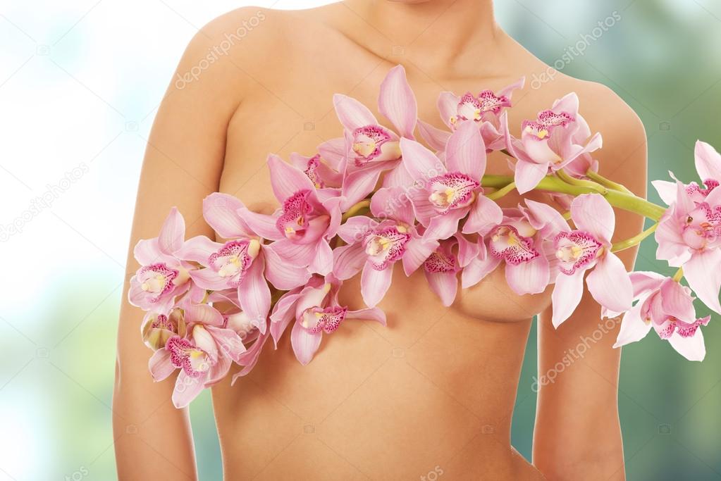 Woman covering breast with flower.
