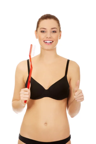 Woman holding red huge toothbrush — Stock Photo, Image