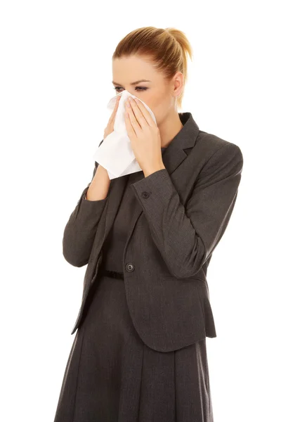 Business woman with an allergy or cold sneezing into tissue — Stock Photo, Image