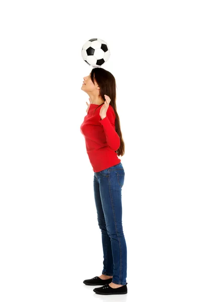 Vrouw met een voetbal op hoofd. — Stockfoto