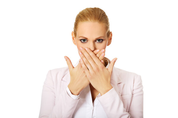 Young business woman covering her mouth with two hands