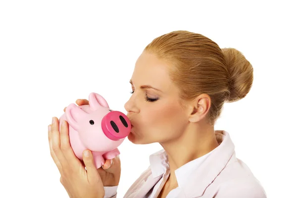 Young business woman kissing a piggybank — Stock Photo, Image