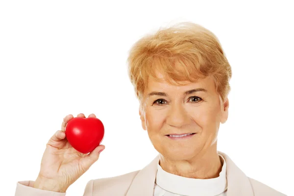 Uśmiech starsza kobieta trzyma model serca — Zdjęcie stockowe