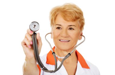 Yaşlı kadın doktor stetoskop tutarak gülümseyin