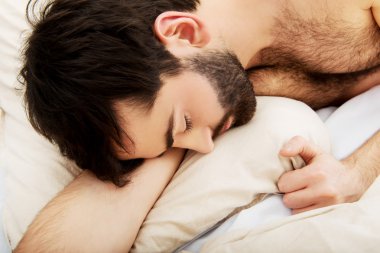 Genç adam yatakta uyuyor..