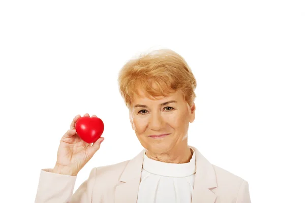 Sonrisa anciana mujer sosteniendo corazón modelo —  Fotos de Stock