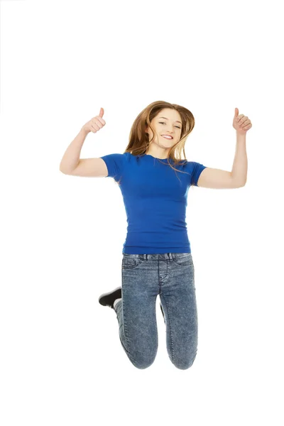 Jumping teenager with thumbs up. — Stock Photo, Image