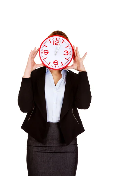 Mujer de negocios cubriendo la cara con un reloj — Foto de Stock