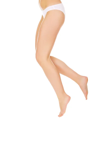 Benen och undersidan av hoppande kvinna i vita trosor — Stockfoto