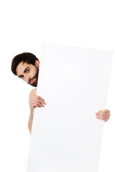 Jovem sem camisa homem segurando banner vazio . — Fotografia de Stock