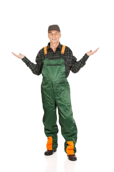 Gardener in uniform showing space with both hands — Stock Photo, Image