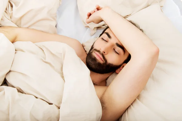 Jonge man slapen in bed. — Stockfoto