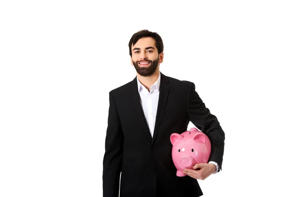 Empresário que detém um Piggy Bank. — Fotografia de Stock