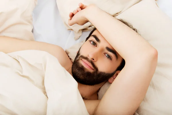 Junger Mann liegt im Bett. — Stockfoto