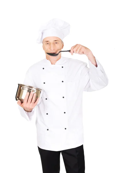 Szef kuchni w biały uniform, degustacja jego zupa — Zdjęcie stockowe