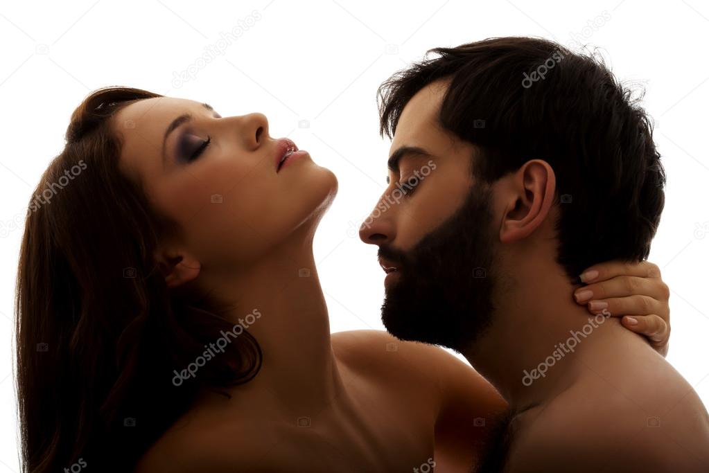 Caucasian man kissing womans neck.