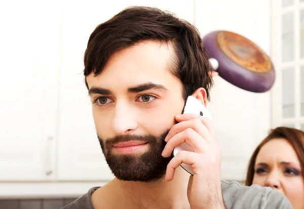 Irritado jovem mulher batendo homens com frigideira. — Fotografia de Stock