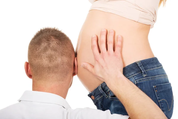 Father listening to mothers pregnant tummy — Stock Photo, Image