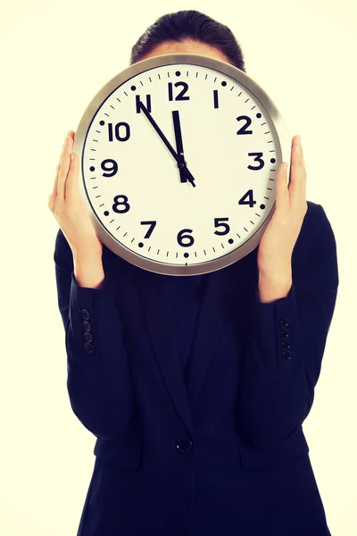 Geschäftsfrau mit großer Uhr. Stockfoto