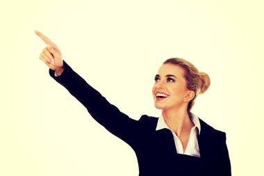 bir şeye işaret eden genç iş kadını