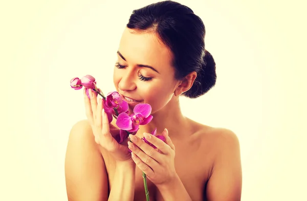 Mujer topless con rama de orquídea púrpura — Foto de Stock