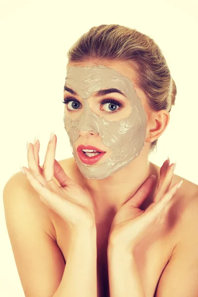 Young surprised woman with facial mask — Stock Photo, Image