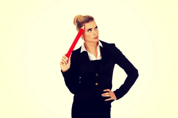Young businesswoman thinking with big pen — Stock Photo, Image