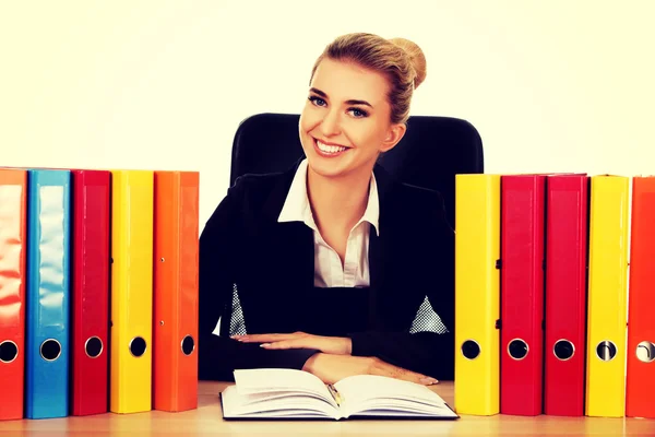 Smile businesswoman with binders by a desk — Stock Photo, Image