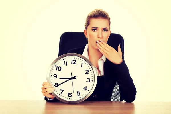 Empresaria bostezando con un reloj —  Fotos de Stock