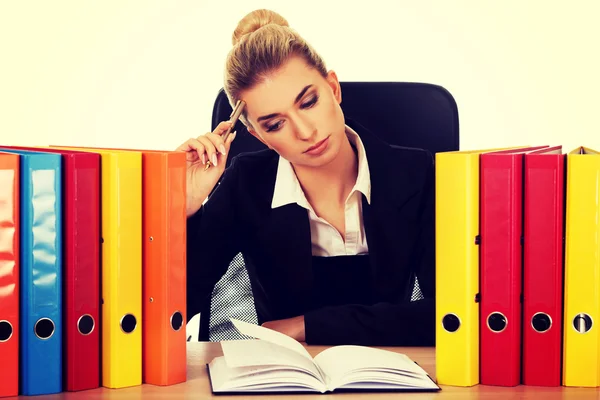 Exhausted businesswoman with binders behind the desk — Stock Photo, Image