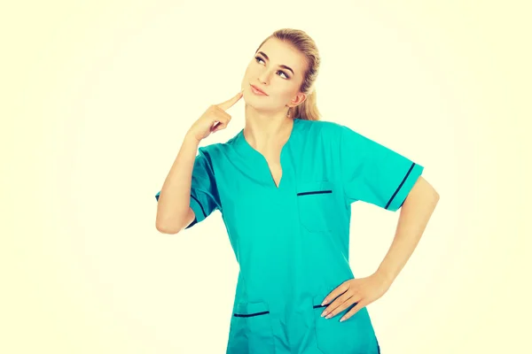 Χαμογελώντας θηλυκό νοσοκόμα να σκεφτόμαστε κάποια ιδέα — Φωτογραφία Αρχείου