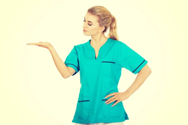 Mujer sonriente médico o enfermera señalando algo — Foto de Stock