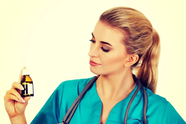 Female nurse or doctor holding medicine bottle in the hand — Stock Photo, Image