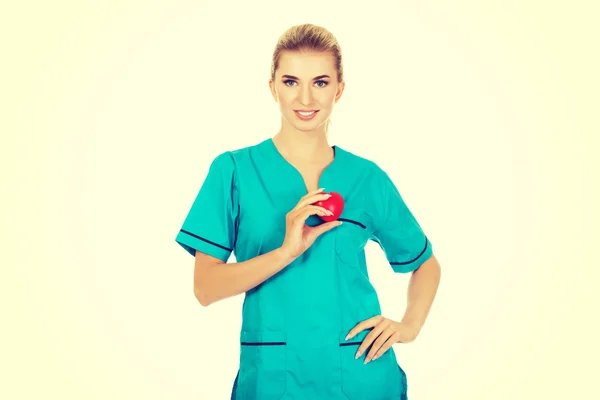 Smiling nurse or female doctor with heart — Stock Photo, Image