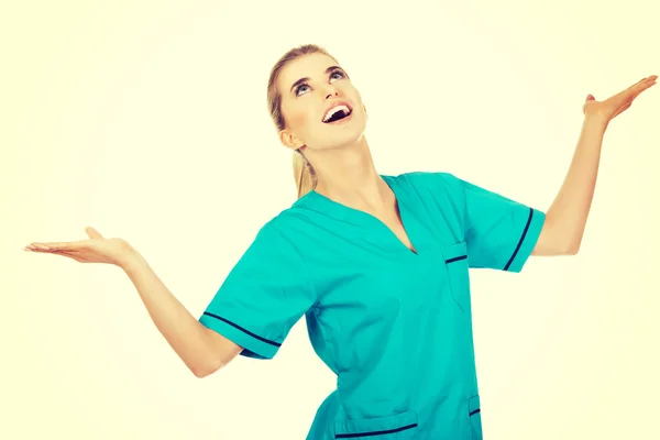 Jovem sorrir mulher médico ou enfermeira pega algo do ar — Fotografia de Stock