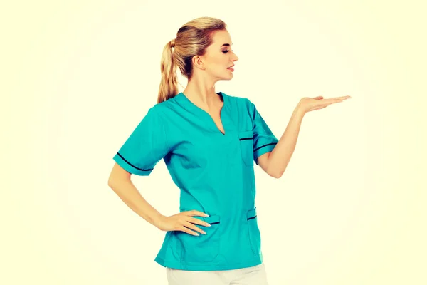 Χαμογελαστή γυναίκα γιατρό ή νοσοκόμα που δείχνει κάτι — Φωτογραφία Αρχείου