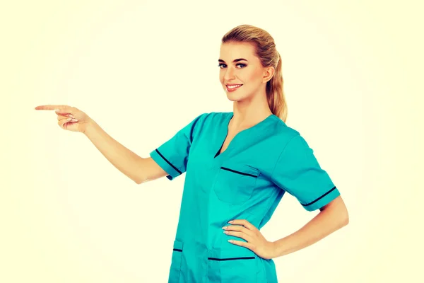 Mujer sonriente médico o enfermera señalando algo — Foto de Stock