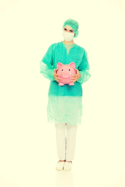 Ženský lékař doktor drží prasátko — Stock fotografie