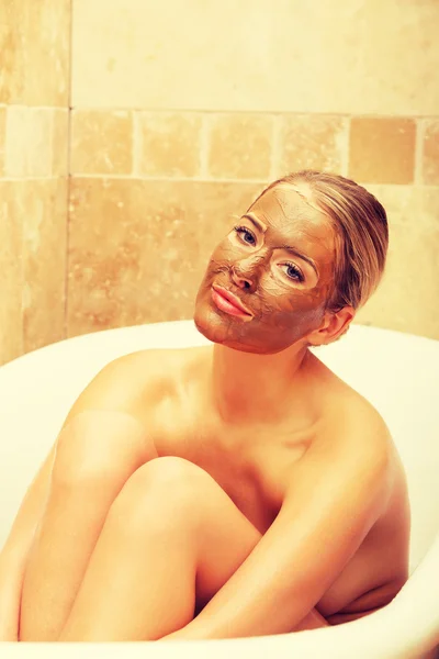 Mujer sentada en un baño con mascarilla — Foto de Stock