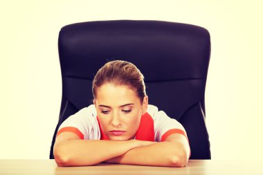 Masanın arkasında oturan yorgun genç kadın doktorunuzya hemşire