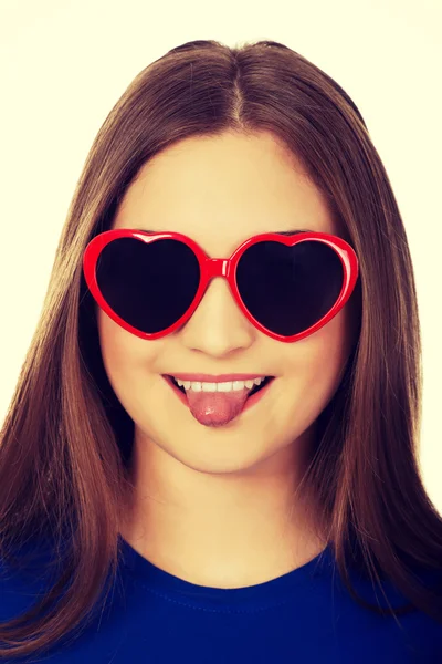 Dospívající žena v sluneční brýle ukazuje jazyk. — Stock fotografie