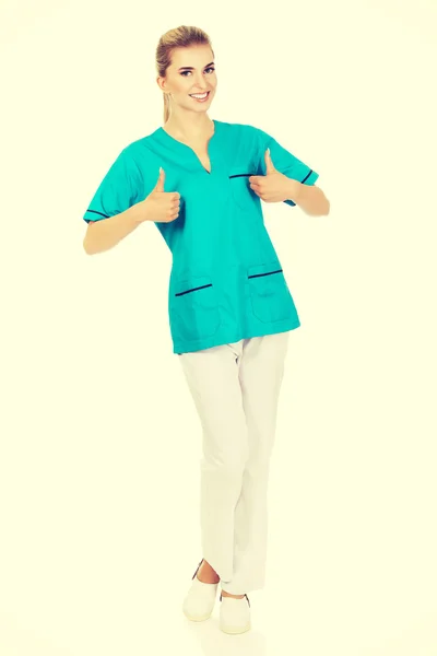 Uśmiechnięta kobieta lekarz lub pielęgniarka z kciuk — Zdjęcie stockowe