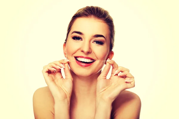 Mujer joven con dientes de hilo dental . — Foto de Stock