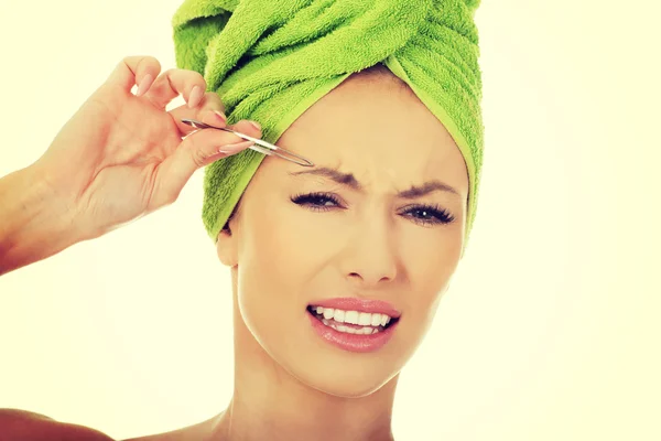 Beautiful woman plucking her eyebrow. — Stock Photo, Image