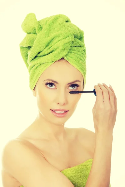 Vrouw met tulband toepassing make up. — Stockfoto