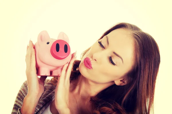 Casual woman kissing piggy-bank. — Stock Photo, Image